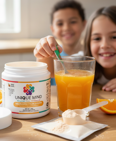 Children enjoying a glass of orange juice with a container of 'Unique Mind' supplement on a table.
